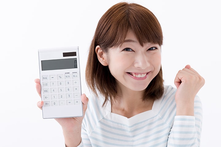 電卓を片手に喜ぶ女性